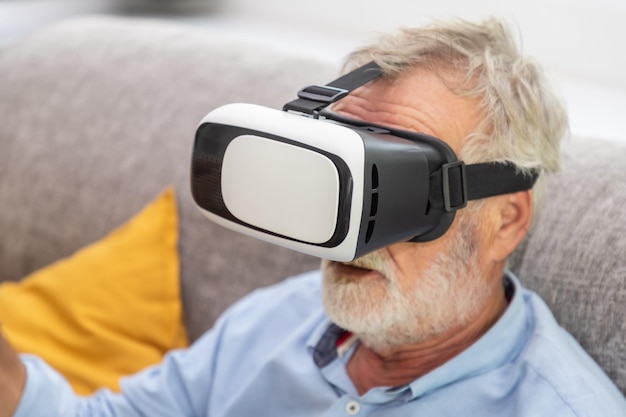Ältere alte Männer genießen es, mit der VR-Virtual-Reality-Brille auf dem Sofa zu spielen