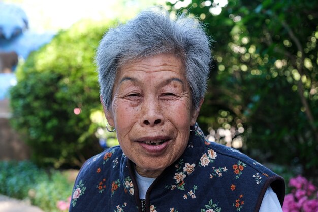 Ältere chinesische Frau, die in einem öffentlichen Park aufwirft.