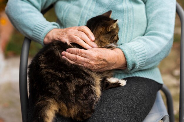 Ältere Frau am Pflegeheim, das Katze hält