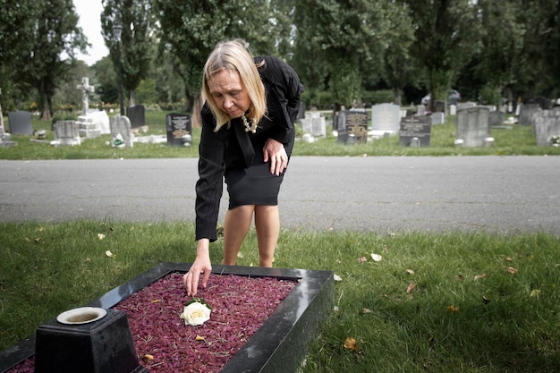 Ältere Frau besucht das Grab eines geliebten Menschen