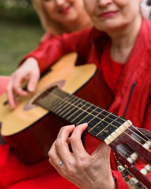 Ältere Frau der Nahaufnahme, die Gitarre spielt