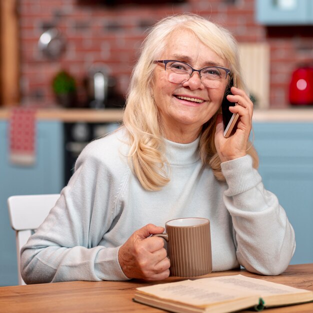 Ältere Frau der Vorderansicht, die über Telefon spricht