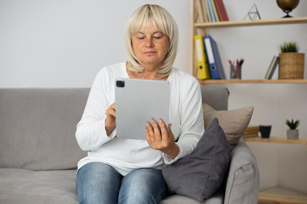 Ältere Frau, die an einem Online-Kurs auf ihrem Tablet teilnimmt