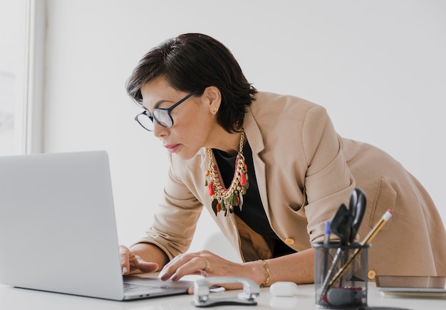 Ältere Frau, die an Laptop arbeitet