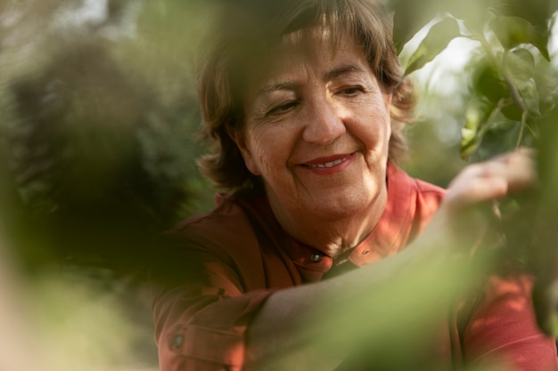 Ältere Frau, die die Natur in ihrem ländlichen Hausgarten genießt