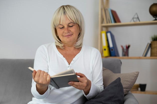 Ältere Frau, die ein Buch für ihre nächste Klasse liest