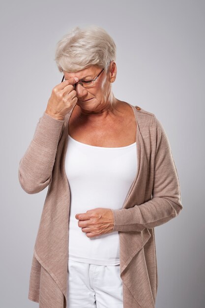 Ältere Frau, die unter starken Kopfschmerzen leidet
