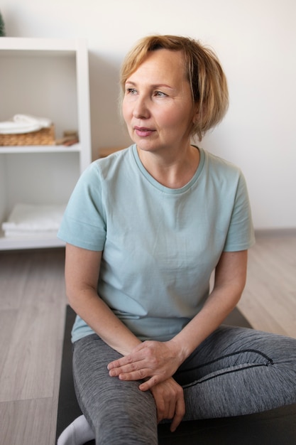 Ältere Frau, die zu Hause Yoga macht