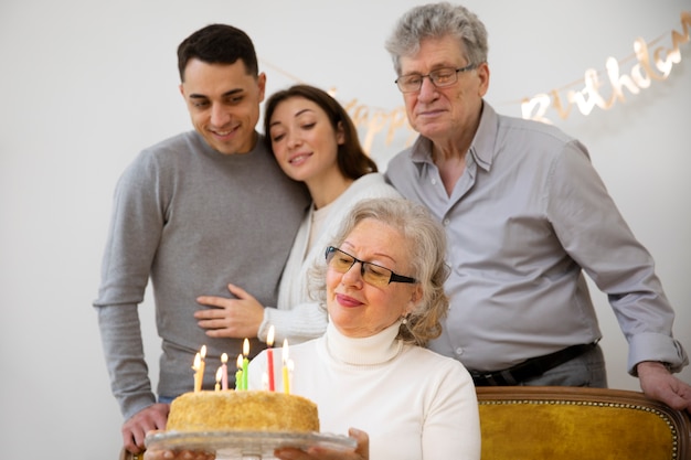 Ältere Frau mit mittlerer Aufnahme, die Kuchen hält