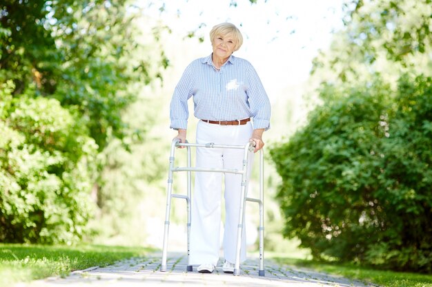 Ältere Frau mit Rollator im Park