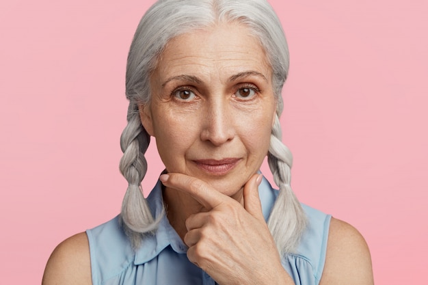 Ältere Frau mit Zöpfen posiert