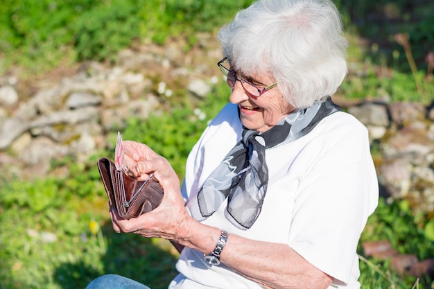 Ältere Frau nach etwas in ihrer Handtasche suchen