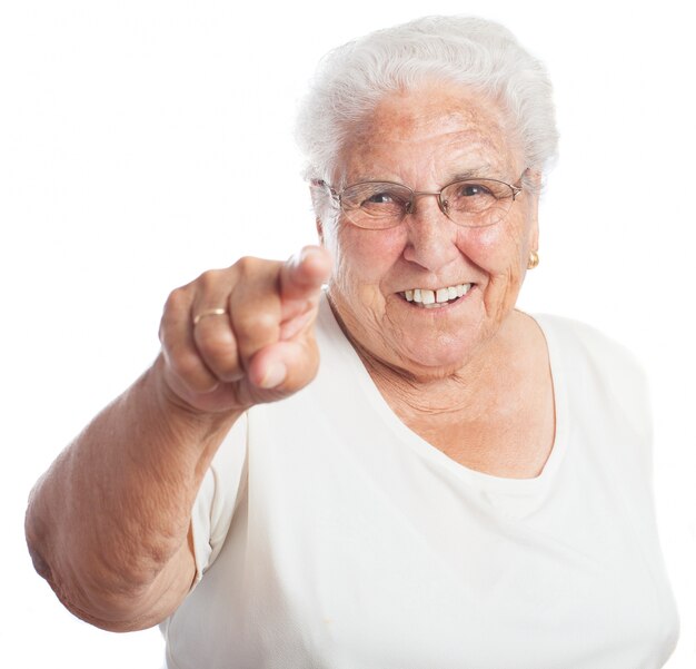 Ältere Frau zeigt lächelnd auf der Vorderseite