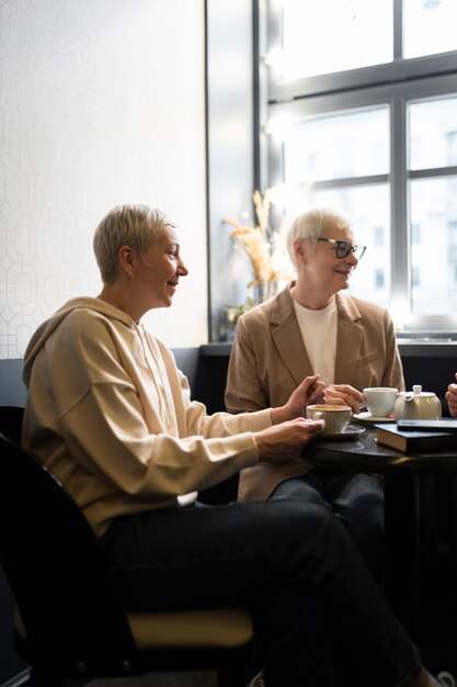 Ältere Frauen, die während einer Versammlung Kaffee trinken