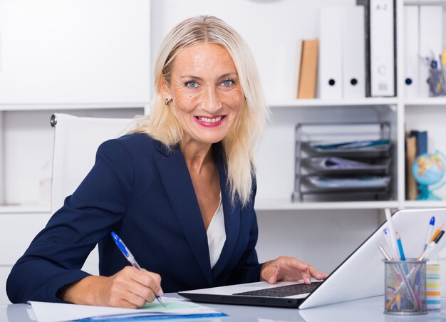 Ältere lächelnd geschäftsfrau arbeiten im Büro