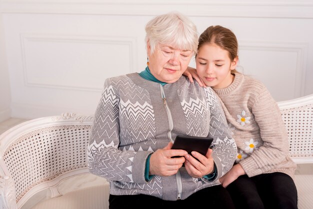 Ältere Oma liest mit ihrer Enkelin