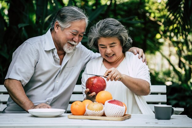 Ältere Paare, die etwas Obst spielen und essen