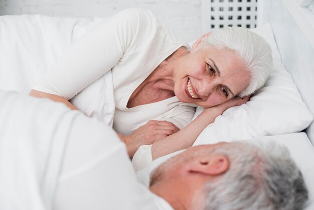 Ältere Paare, die im Bett stillstehen