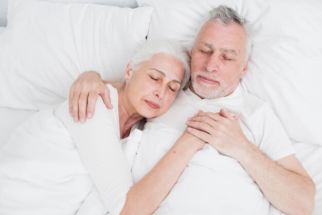 Ältere Paare, die im Bett stillstehen