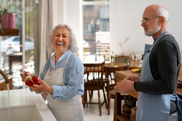 Ältere Paare, die zusammen in der Küche kochen