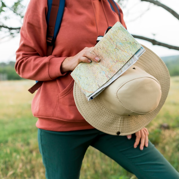 Ältere Touristenfrau, die Hut und Karte hält