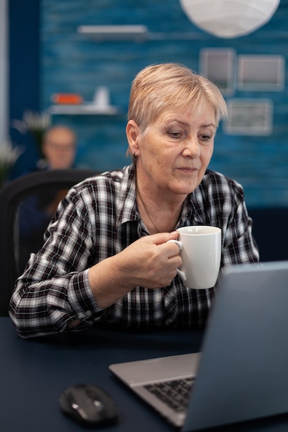 Ältere Unternehmerin, die am Computer liest
