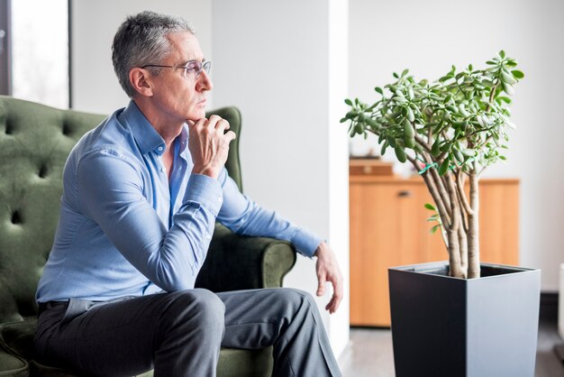 Älterer Geschäftsmann, der auf einem Sofa aufwirft