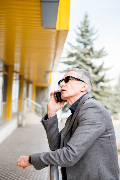 Älterer Geschäftsmann, der durch Telefon spricht