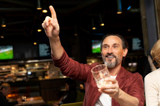 Älterer Mann, der den Kellner in einem Restaurant anruft