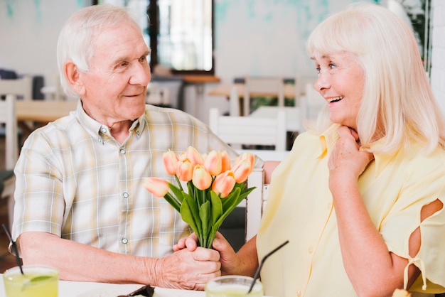 Älterer Mann, der geliebten Blumen gibt