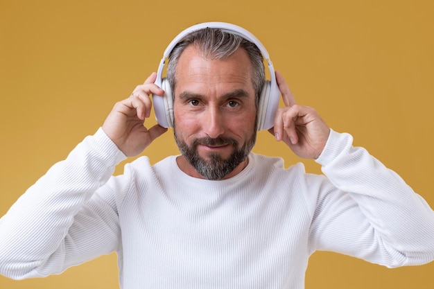 Älterer Mann, der Musik über Kopfhörer hört