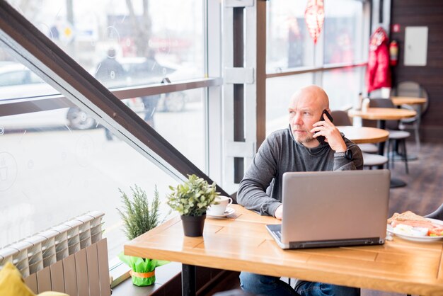 Älterer Mann, der per Telefon spricht