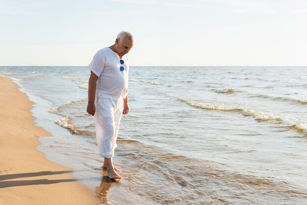 Älterer Mann im Freien, der den Strand genießt