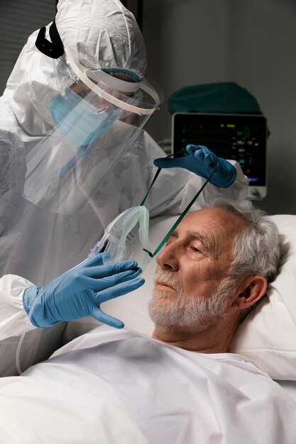 Älterer Mann mit Beatmungsgerät in einem Krankenhausbett