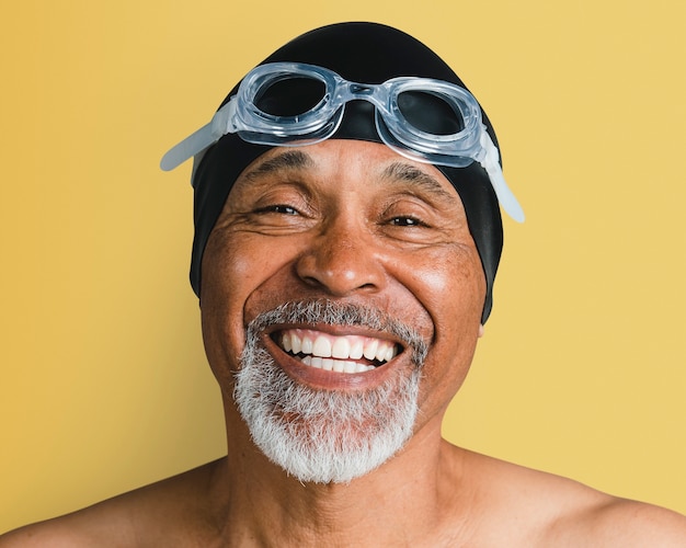 Älterer Mann mit Schwimmbrille, lächelndes Gesichtsporträt