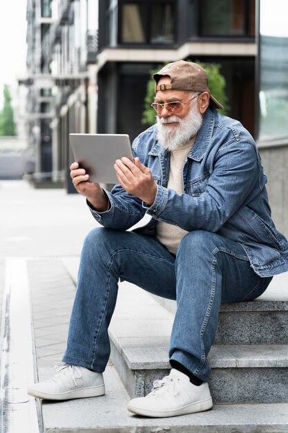 Älterer Mann mit Tablet im Freien in der Stadt