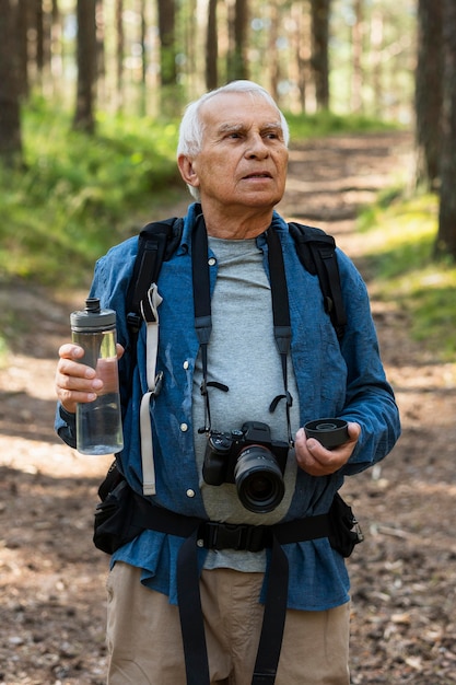 Älterer Mann Rucksack in der Natur mit Kamera und Wasserflasche