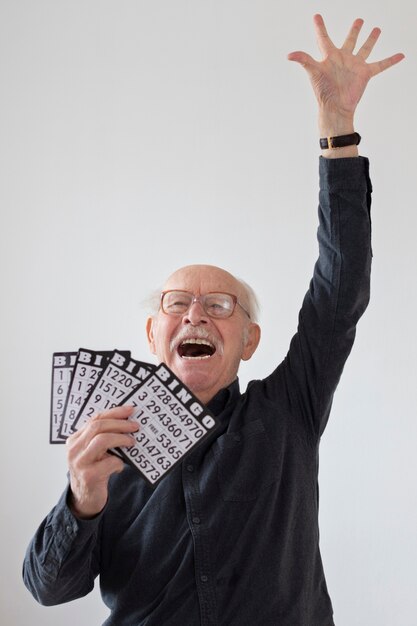 Älterer Mann spielt Bingo mittlerer Schuss