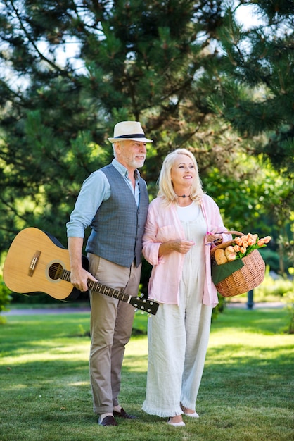 Älteres Ehepaar mit Gitarre und Picknickkorb