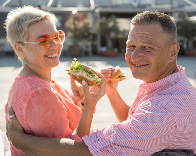 Älteres Paar am Strand genießt einen schönen Burger