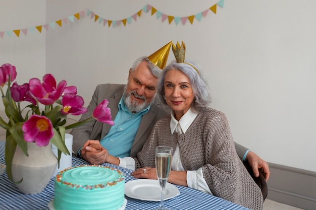 Älteres Paar der mittleren Aufnahme, das mit Kuchen feiert