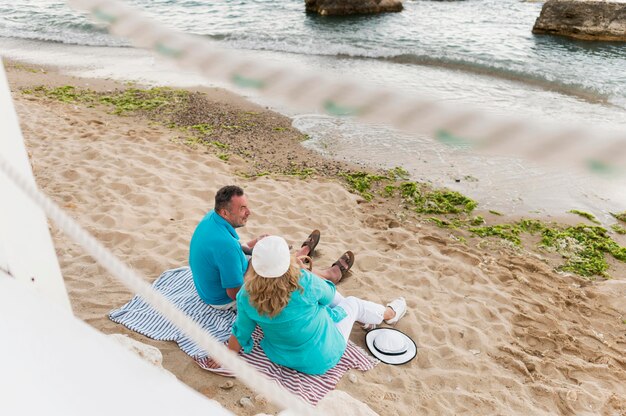 Älteres Touristenpaar, das die Aussicht am Strand genießt