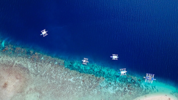 Luftaufnahme der Sandstrand mit Touristen Schwimmen in schönen klaren Meerwasser der Sumilon Insel Strand Landung in der Nähe von Oslob, Cebu, Philippinen. - Farbverarbeitung verstärken.
