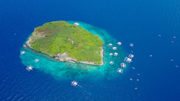 Luftaufnahme der Sandstrand mit Touristen Schwimmen in wunderschönen klaren Meerwasser der Sumilon Insel Strand Landung in der Nähe von Oslob, Cebu, Philippinen. - Farbverarbeitung verstärken.