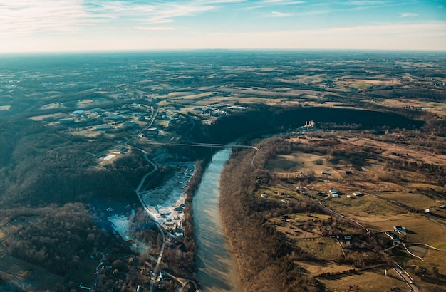 Luftaufnahme der schönen Straßen, des Flusses und des Feldes mit einem sonnigen blauen Himmel