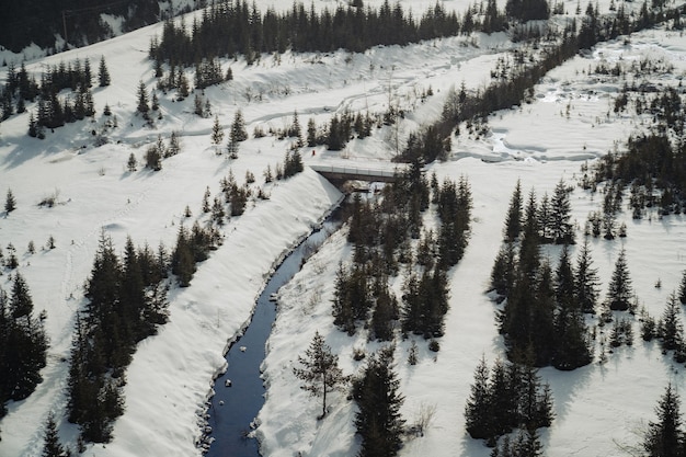 Luftaufnahme der schönen verschneiten Landschaft mit Bach