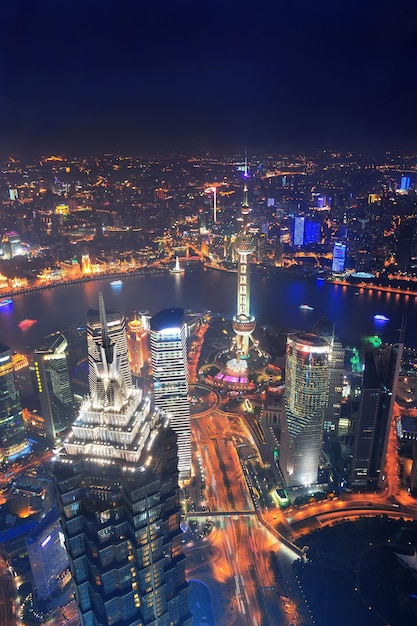 Luftaufnahme der Stadt Shanghai bei Nacht mit Lichtern und urbaner Architektur