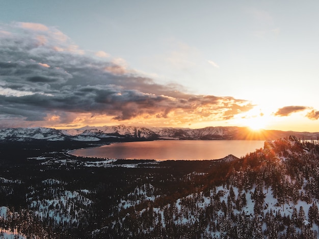 Kostenloses Foto luftaufnahme des schönen lake tahoe, der auf einem verschneiten sonnenuntergang in kalifornien, usa gefangen genommen wird