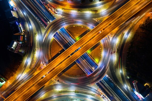 Luftaufnahme des Verkehrs im Kreisverkehr und auf der Autobahn bei Nacht