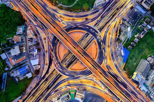 Luftaufnahme des Verkehrs im Kreisverkehr und auf der Autobahn bei Nacht.